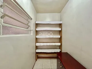 Hall de corredor com janela e estante de madeira na decoração.