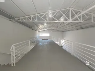 Espaço interno com teto de treliça e corrimãos brancos.