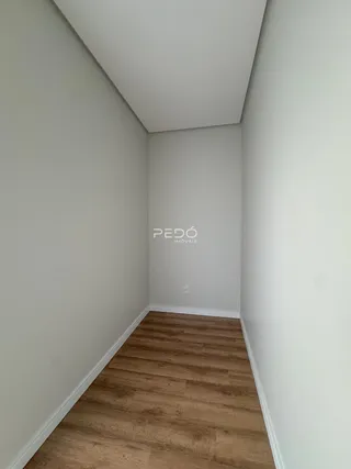 Hall de corredor com piso de madeira clara.