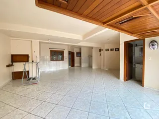Ambiente interno amplo com piso de cerâmica e forro de madeira.