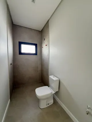 Foto de um banheiro com vaso sanitário e janela.