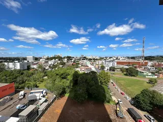 Vista aérea de uma área residencial com paisagem urbana ao fundo.