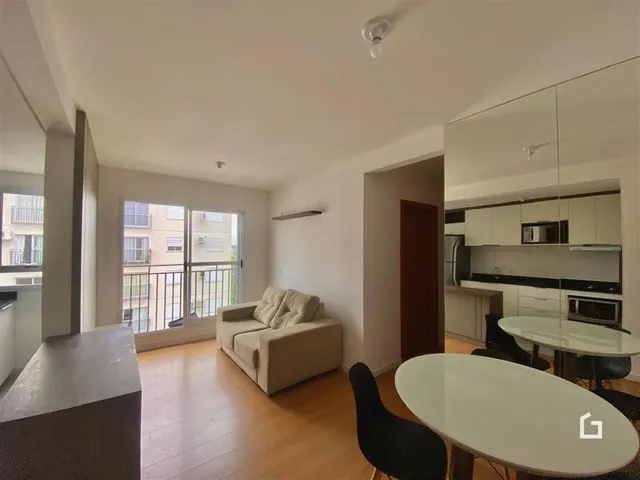 Sala de estar com piso de madeira e vista para o exterior.