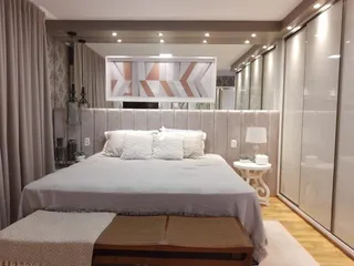 Quarto com cama e roupa de cama em um ambiente interno.