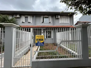 Fachada de uma casa em Lajeado, Brasil, com cerca e portão de metal branco.