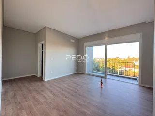 Sala de estar com piso de madeira e vista para a varanda.
