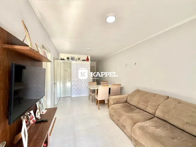 Sala de estar com sofá e televisão em um apartamento.