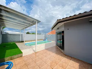 Vista externa de uma área de piscina e jardim em uma propriedade no Brasil.