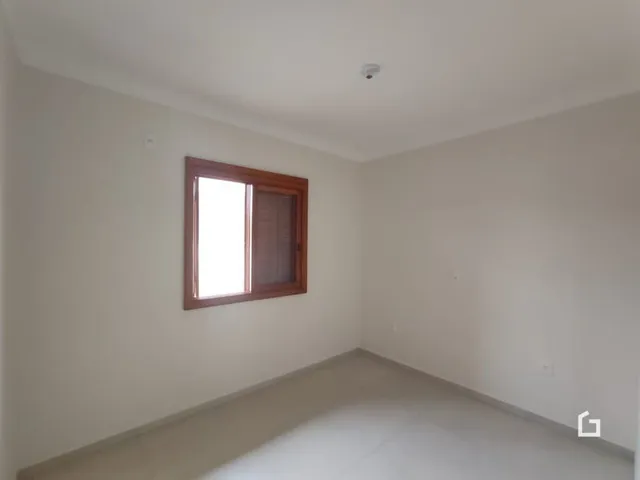 Interior de um cômodo com parede branca e porta de madeira.