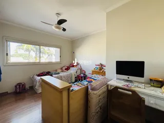 Quarto com janela e piso de madeira em imóvel no Brasil.