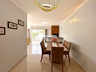 Foto do ambiente de jantar com mesa de madeira e cadeiras em uma residência.