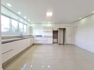 Interior de uma área com armários brancos e piso claro.