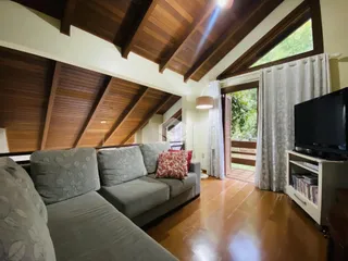 Sala de estar com pé direito alto e forro de madeira.