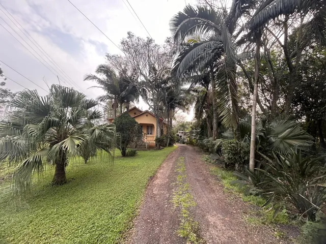 Foto da fachada de uma residência em Lajeado, Brasil, cercada por vegetação exuberante.