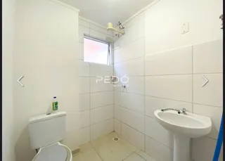 Foto de um banheiro com revestimento cerâmico branco.