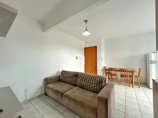 A sala de estar mostra um sofá e um piso de cerâmica claro.