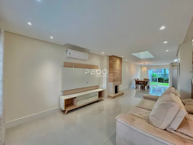 Sala de estar moderna com piso de cerâmica e móveis claros.