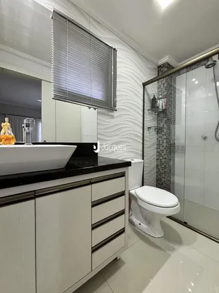 Foto de um banheiro moderno com bancada escura e revestimento de azulejos.