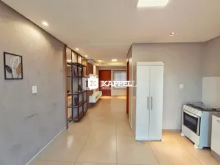 Hall de entrada com estantes de madeira e armários brancos.