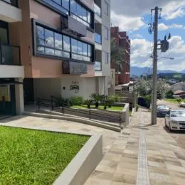 Vista externa de um jardim com piso de concreto e paisagismo em uma propriedade em Lajeado.