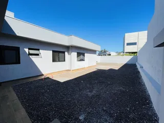Fachada de uma residência moderna em Lajeado, Brasil, com área externa pavimentada.