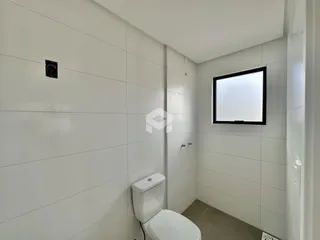 Foto de um banheiro interno com paredes brancas e piso claro.