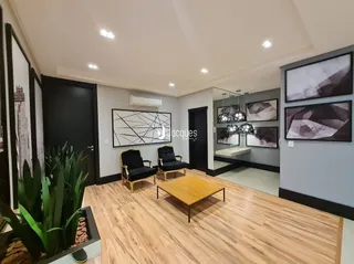 Sala de estar com piso de madeira e obra de arte na parede.
