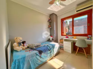 Quarto com cama e janela de madeira.