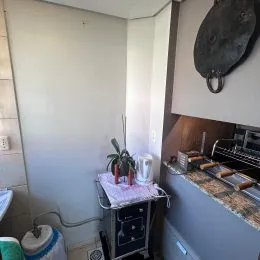 Foto de uma área de cozinha com bancada escura e fogão.