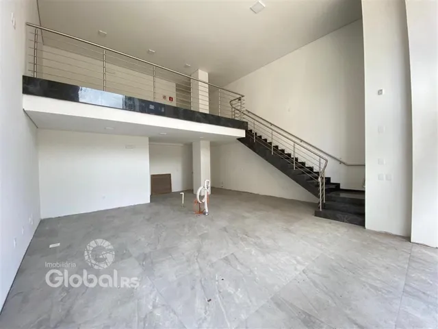 Vista interna de um espaço aberto com escadaria e mezanino em uma residência.