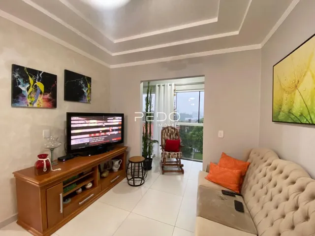 Sala de estar com sofá e painel decorativo em um apartamento.
