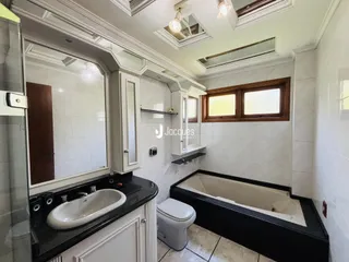 Foto de um banheiro com banheira e revestimento cerâmico branco.