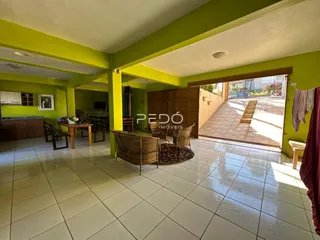 Ambiente interno de uma sala de estar com piso de cerâmica e vista para o exterior.