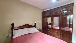 Quarto com cabeceira de madeira e armários embutidos.
