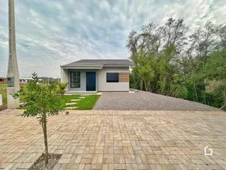 Fachada de uma residência em Lajeado, Brasil, com jardim e área pavimentada.