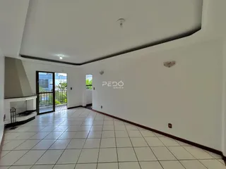 Ambiente interno de uma sala com piso de cerâmica e parede branca.