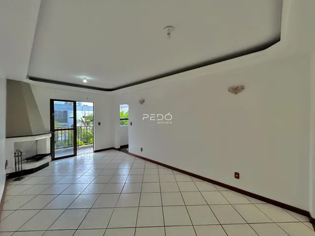 Ambiente interno de uma sala com piso de cerâmica e parede branca.