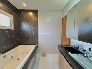 Foto de um banheiro com banheira e revestimento de mármore escuro.