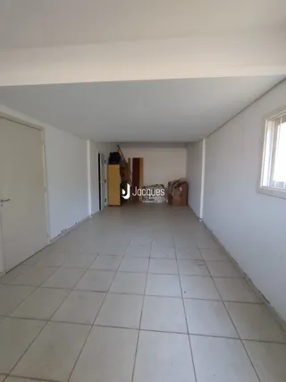 A foto mostra um corredor interno com piso de cerâmica.