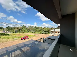 Vista externa de uma propriedade com paisagem rural ao fundo.