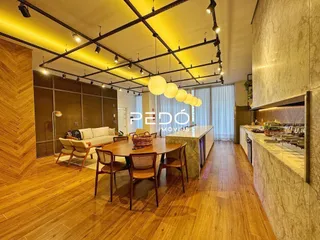 Imagem de uma sala de jantar com piso de madeira e estrutura de teto exposta.