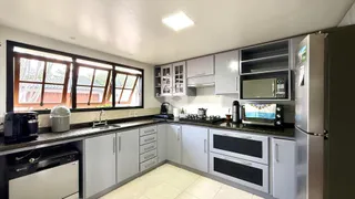 Cozinha com grandes janelas que oferecem vista para o exterior.