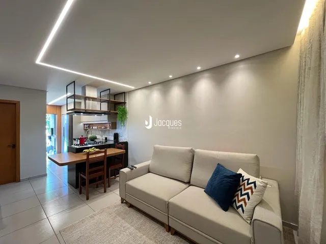 Sala de estar com sofá e cozinha em um apartamento no Brasil.