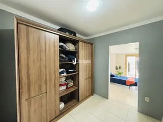 Quarto com armário de madeira e porta de acesso a outro cômodo.