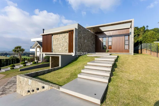Fachada moderna de uma residência com jardim e escadaria externa em Lajeado.