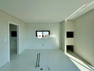Ambiente interno de uma sala ampla com piso de cerâmica e paredes brancas.