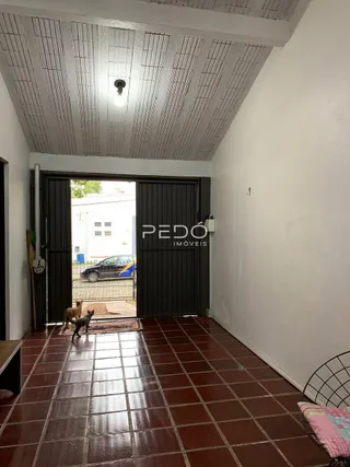 Corredor interno com piso de cerâmica e portas de madeira.
