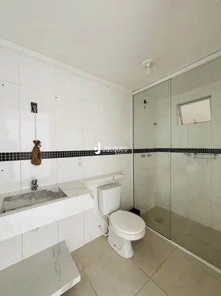 Foto interna de um banheiro com revestimento branco e bancada de mármore.