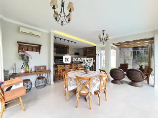 Uma sala de jantar ampla com mesa de madeira e iluminação clara.