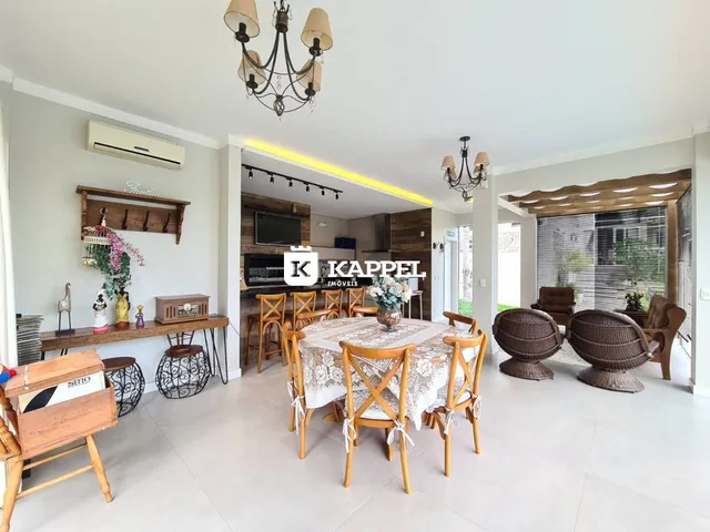 Uma sala de jantar ampla com mesa de madeira e iluminação clara.